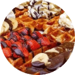 Waffeln mit Puderzucker, heissen Kirschen etc.